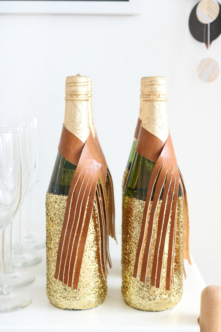 Glitter-Dipped Champagne Bottles with Faux Leather Fringe Detail — Gold New Years Eve Decor