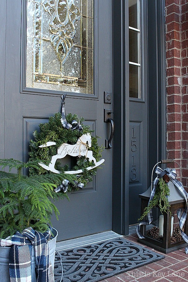 Grey Front Door with Rocking Horse Wreath and Plaid Accents — Winter Front Door Decor