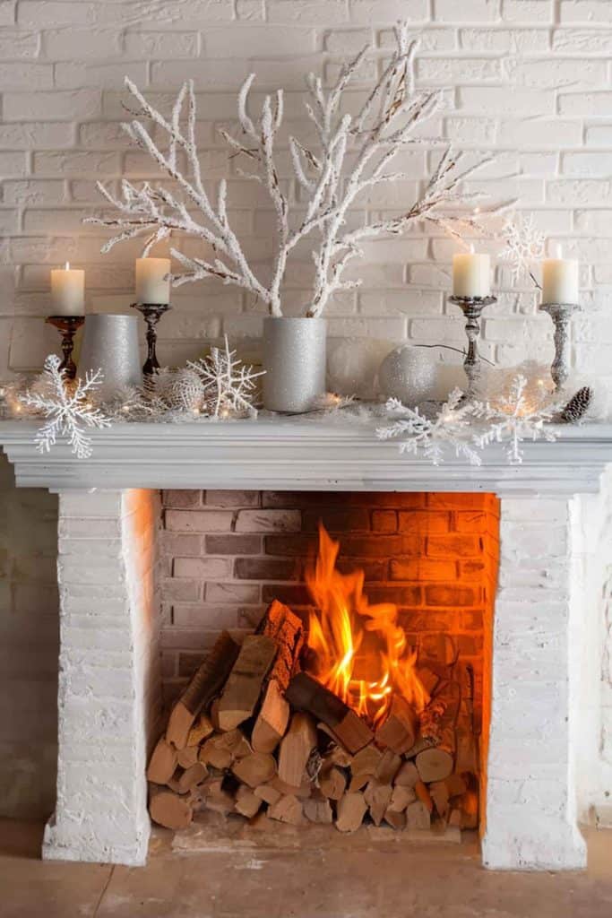 Cozy White Brick Fireplace with Frosted Branches and Snowflakes — Winter Mantel Decor