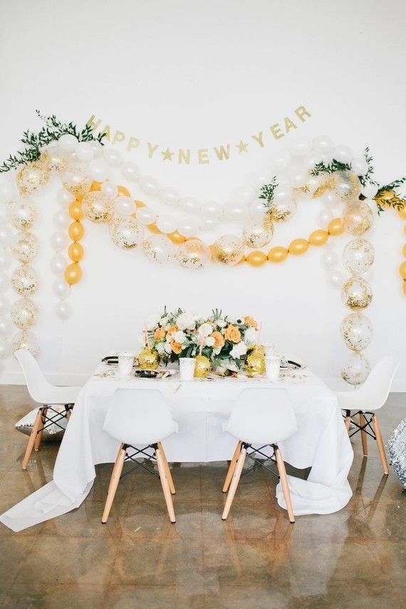 Gold and White Balloon Garland with Greenery Over Dining Table — New Years Eve Balloon Garland