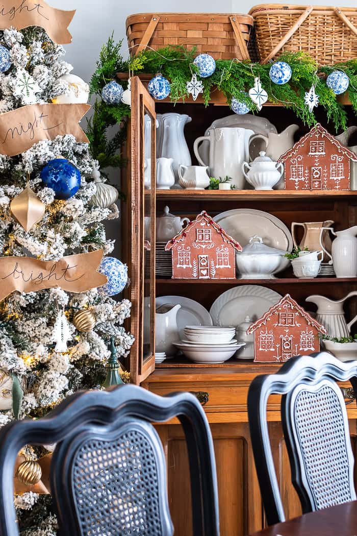 China Cabinet Topped with Gingerbread Houses and Flocked Tree — gingerbread christmas decor ideas 2026